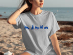 Light grey t-shirt with blue cartoon dogs enjoying ice cream on the beach.