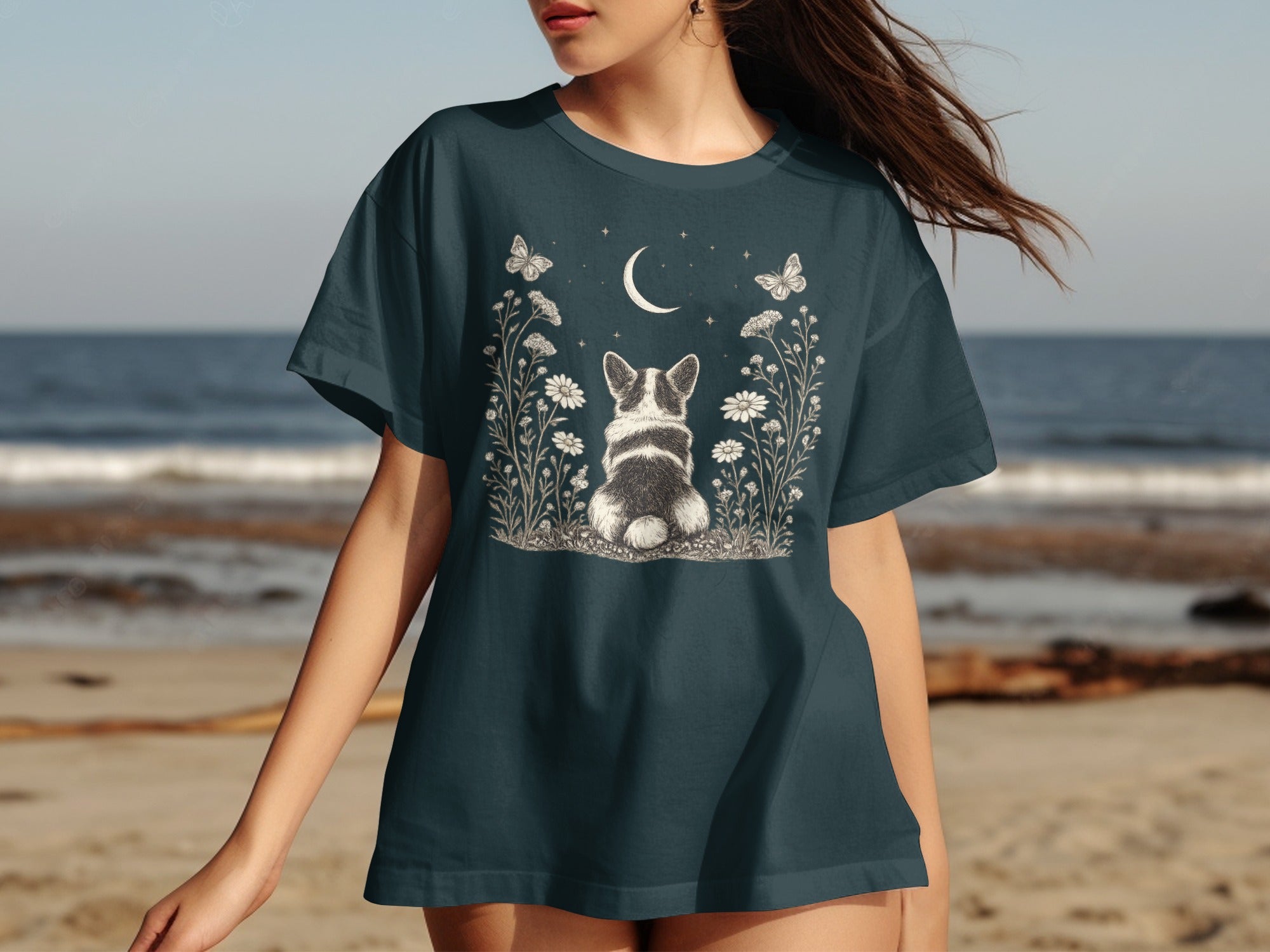 Dark grey t-shirt with illustration of Corgi, crescent moon, stars, flowers, and butterflies.