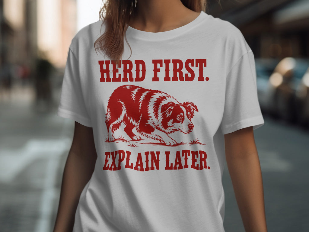 White t-shirt with red text "HERD FIRST. EXPLAIN LATER." and a red border collie.