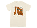 Three brown dogs sit next to each other, one wearing glasses, on a beige t-shirt.
