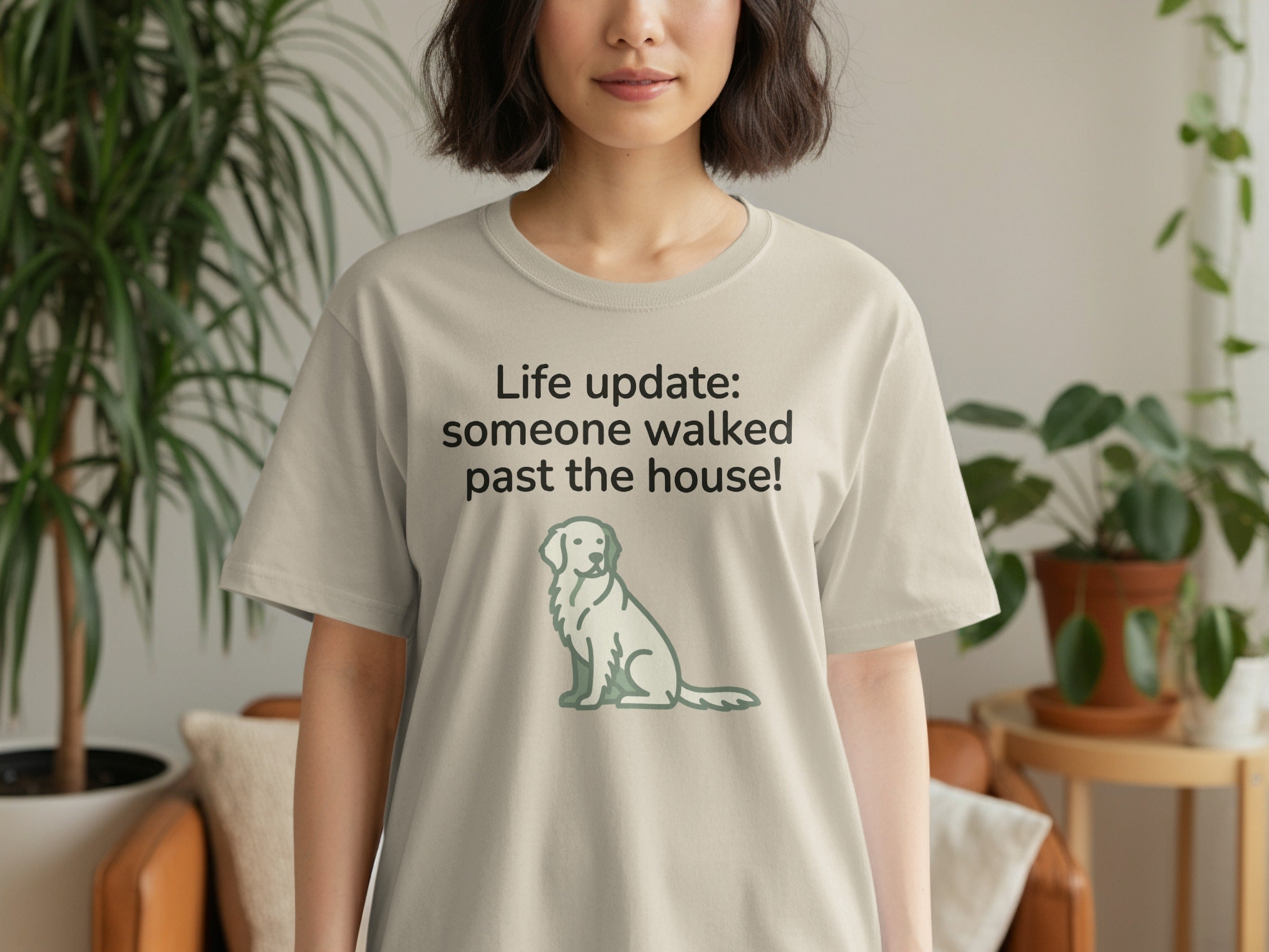 Light gray t-shirt with text "Life update: someone walked past the house!" and a dog illustration.