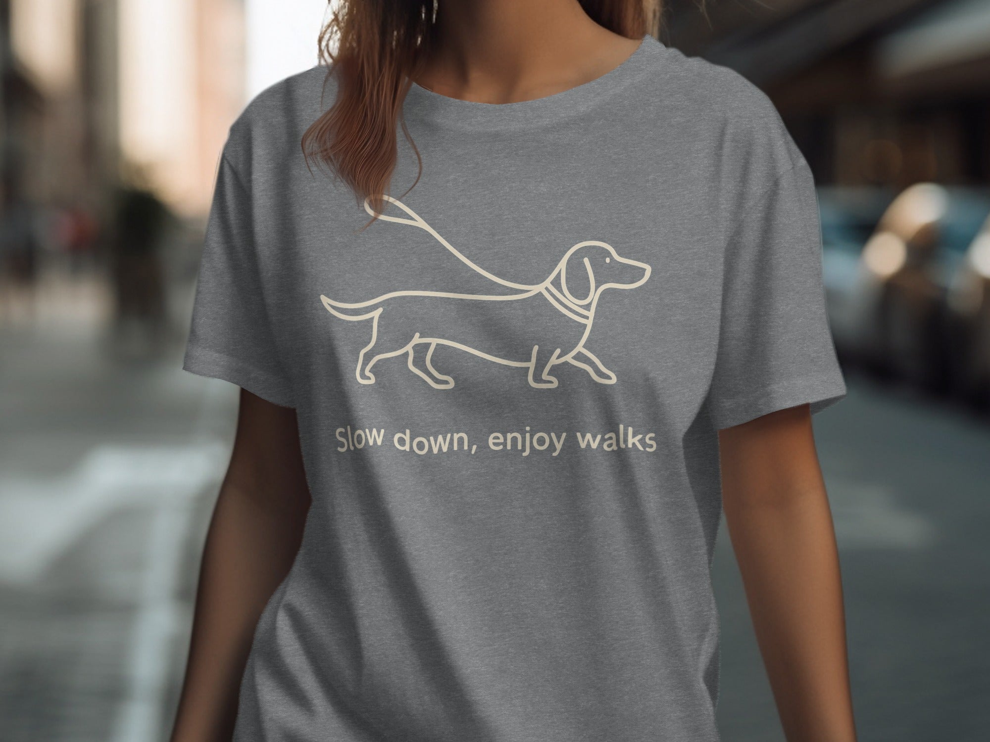 Grey t-shirt with a line drawing of a dachshund and the text "Slow down, enjoy walks".
