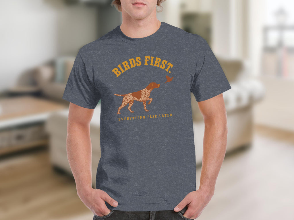 T-shirt with a dog and bird graphic and text "BIRDS FIRST. EVERYTHING ELSE LATER."