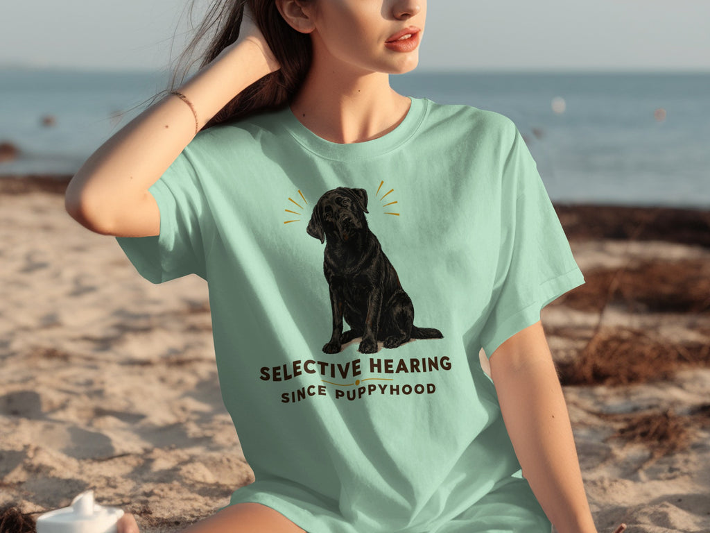 Black dog with "Selective Hearing Since Puppyhood" text on a light blue t-shirt.
