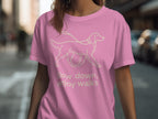 Pink t-shirt with a line drawing of a dog on a leash and text "Slow down, enjoy walks".