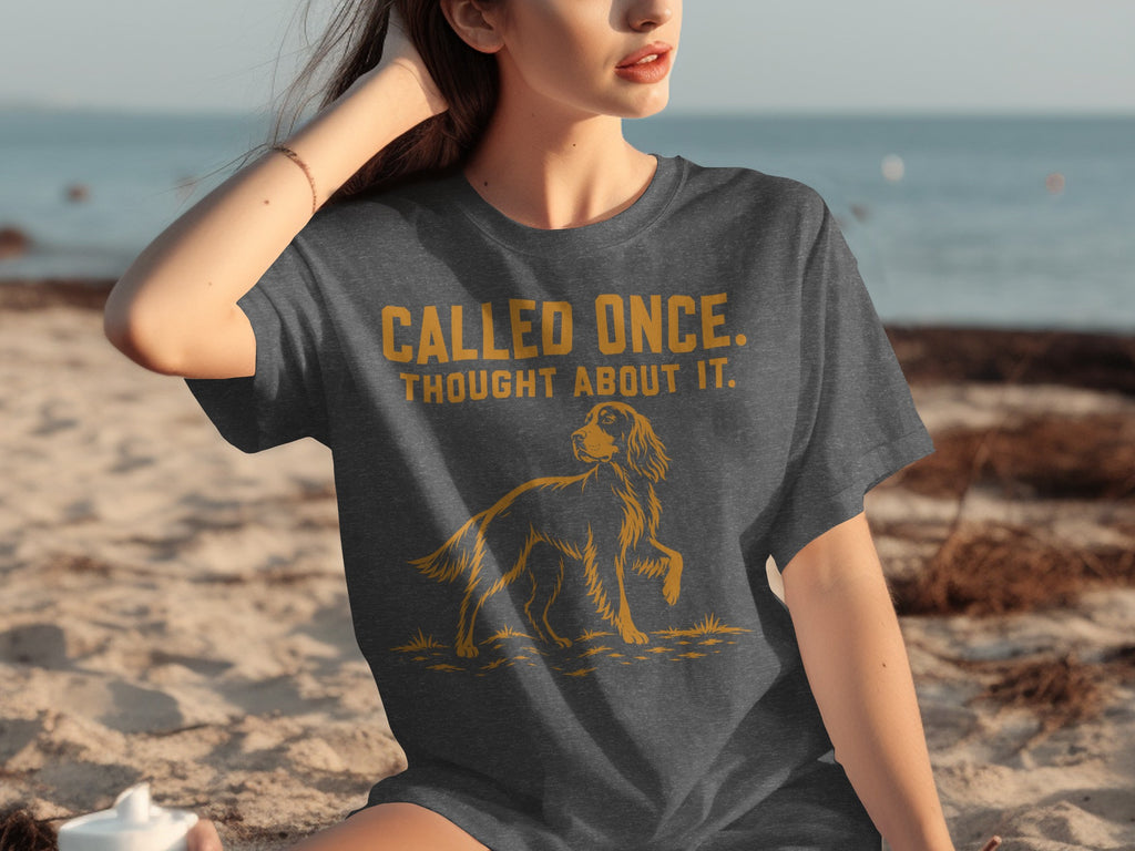 Woman wearing dark grey t-shirt with golden retriever graphic and text.