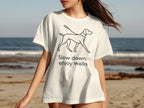 White t-shirt with black line drawing of a dog and text "Slow down, enjoy walks".