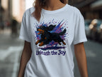 White t-shirt with a black and tan dog illustration and the text "Unleash the Joy."