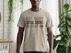 Tan t-shirt with "EAT. SLEEP. STEAL SOCKS. REPEAT." text and dog icon.