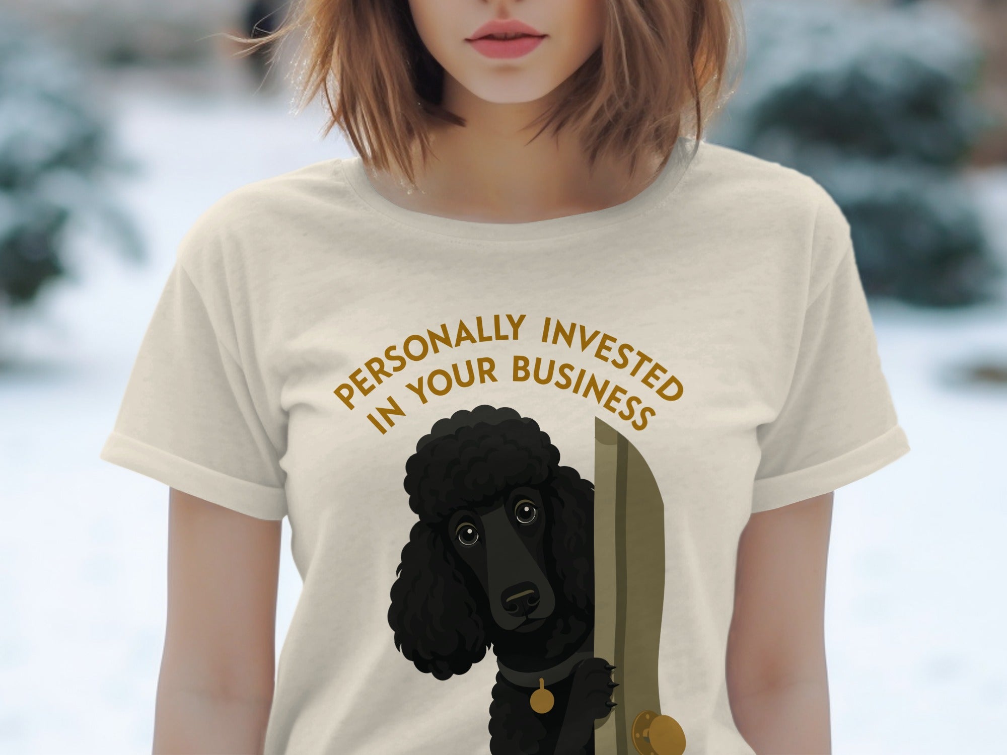 Cream t-shirt with a black poodle peeking from behind a door, text reads "Personally Invested in Your Business".