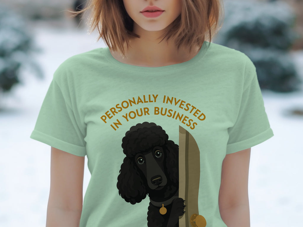 Light green t-shirt with black poodle peeking around a door, text reads "Personally Invested in Your Business".