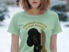 Light green t-shirt with black poodle peeking around a door, text reads "Personally Invested in Your Business".