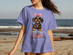 Dachshund in sunglasses and bow on purple t-shirt with text "First of all, I'm a delight."