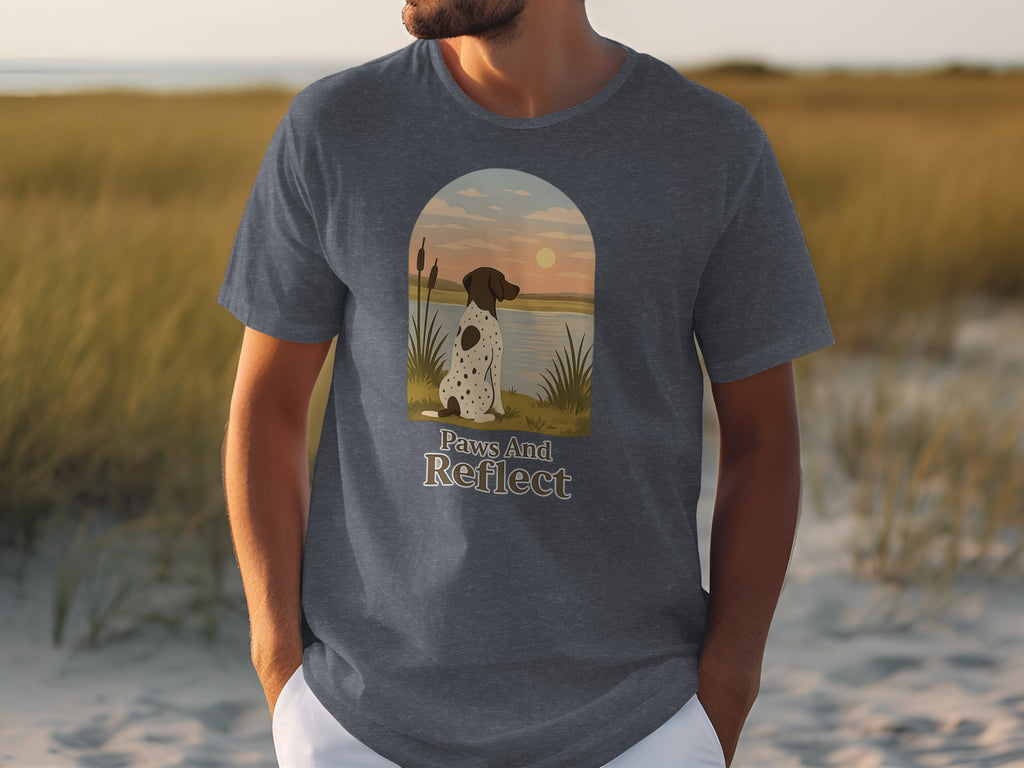 T-shirt graphic: dog sitting by water with "Paws And Reflect" text.