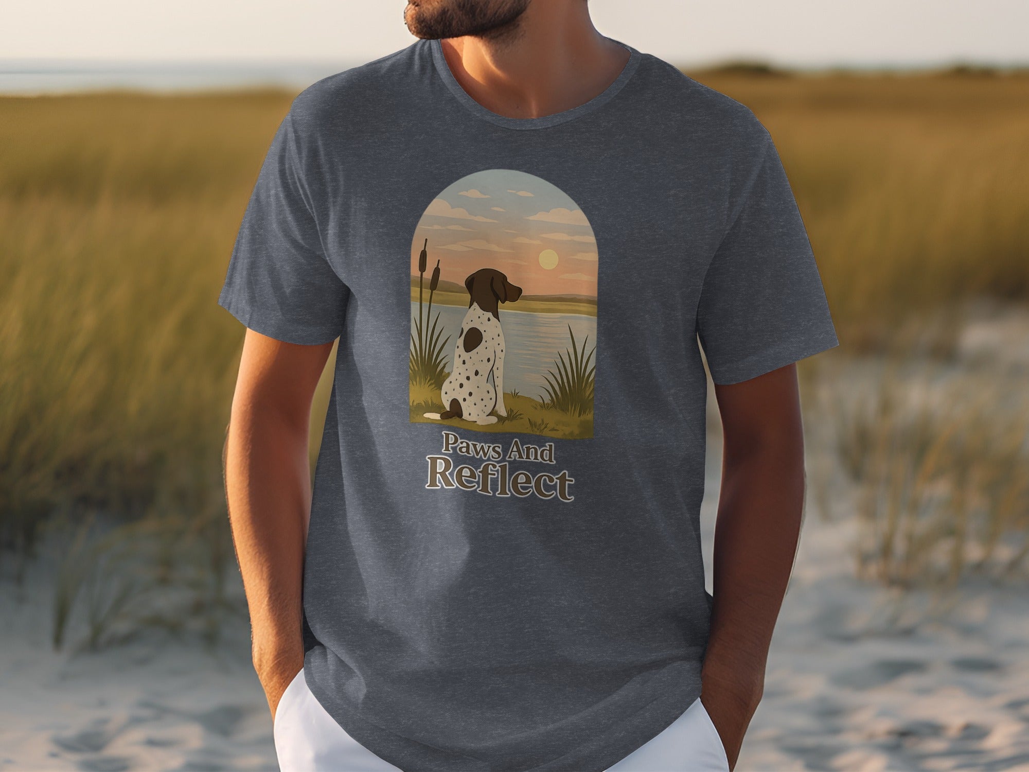 T-shirt graphic: dog sitting by water with "Paws And Reflect" text.