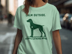 Green t-shirt with dog silhouette and text "CALM OUTSIDE. INTENSELY ATTACHED INSIDE."
