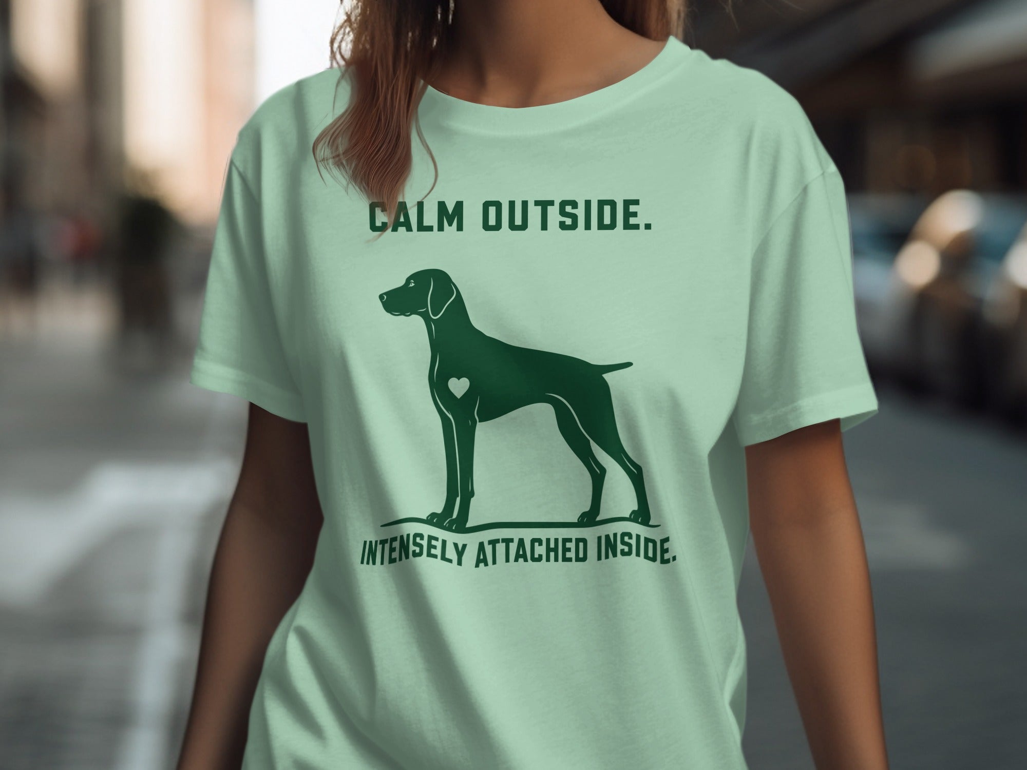 Green t-shirt with dog silhouette and text "CALM OUTSIDE. INTENSELY ATTACHED INSIDE."