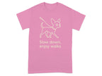 Pink t-shirt with a line drawing of a dog on a leash and text that reads "Slow down, enjoy walks."
