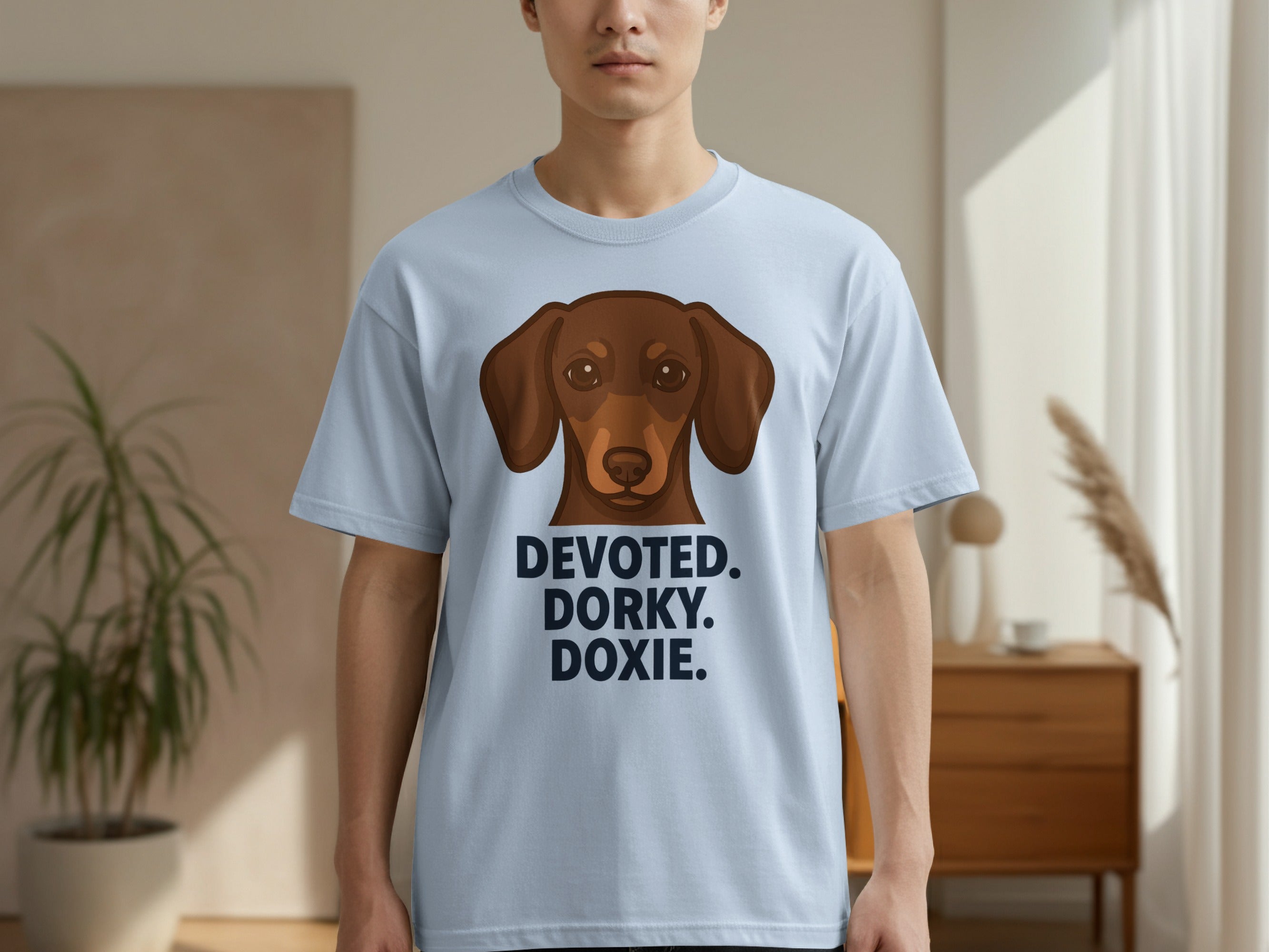 Light blue t-shirt with a brown dachshund and text "DEVOTED. DORKY. DOXIE."