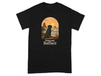 Black t-shirt with silhouette of dog at sunset by the ocean, "Paws And Reflect" text.