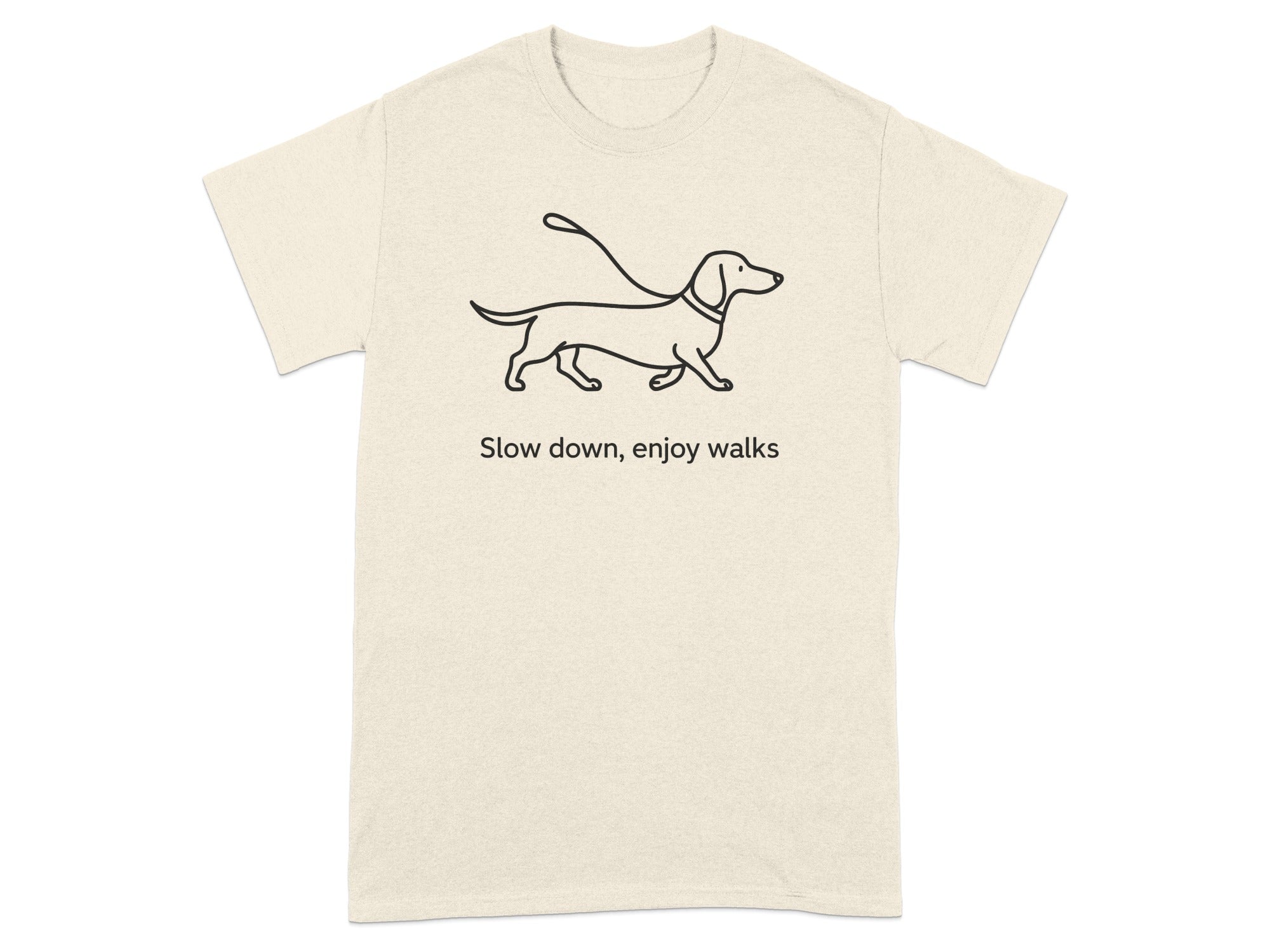 Beige t-shirt with a black dachshund graphic and text "Slow down, enjoy walks".