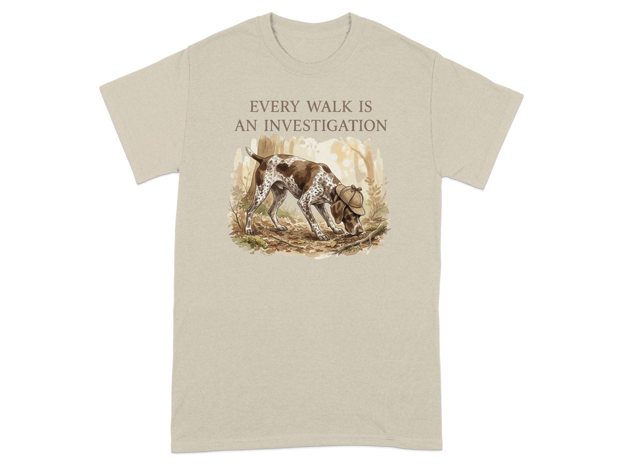 Beige t-shirt with a German Shorthaired Pointer sniffing the ground in a forest.