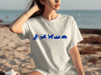 White t-shirt with blue silhouette dogs in various poses on a beach.