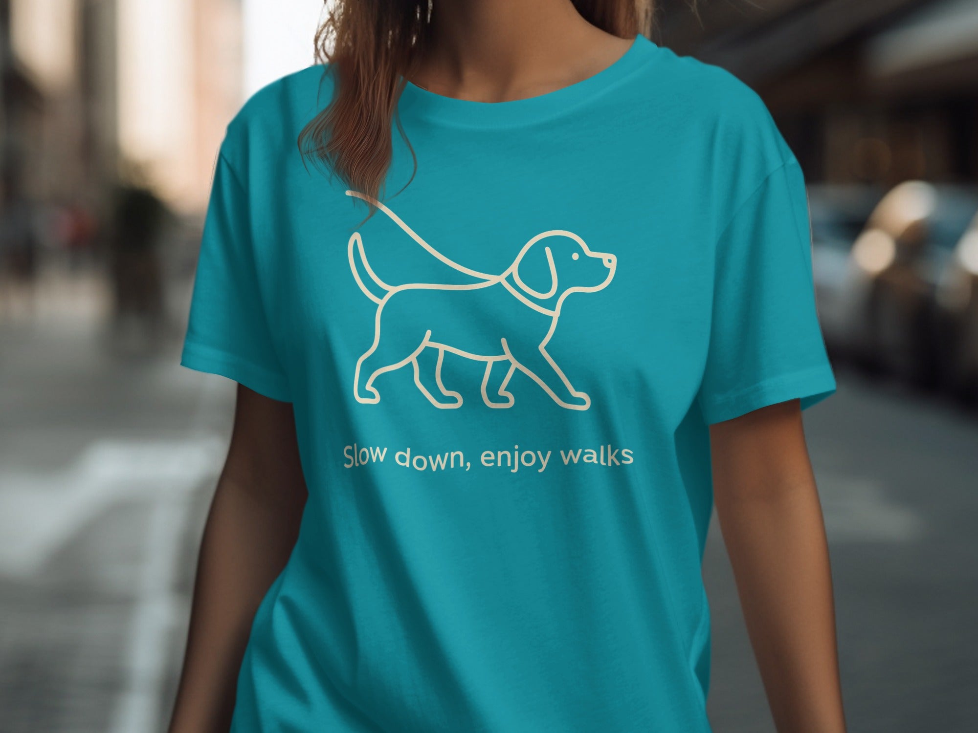 Teal t-shirt with white line drawing of a dog and text "Slow down, enjoy walks".