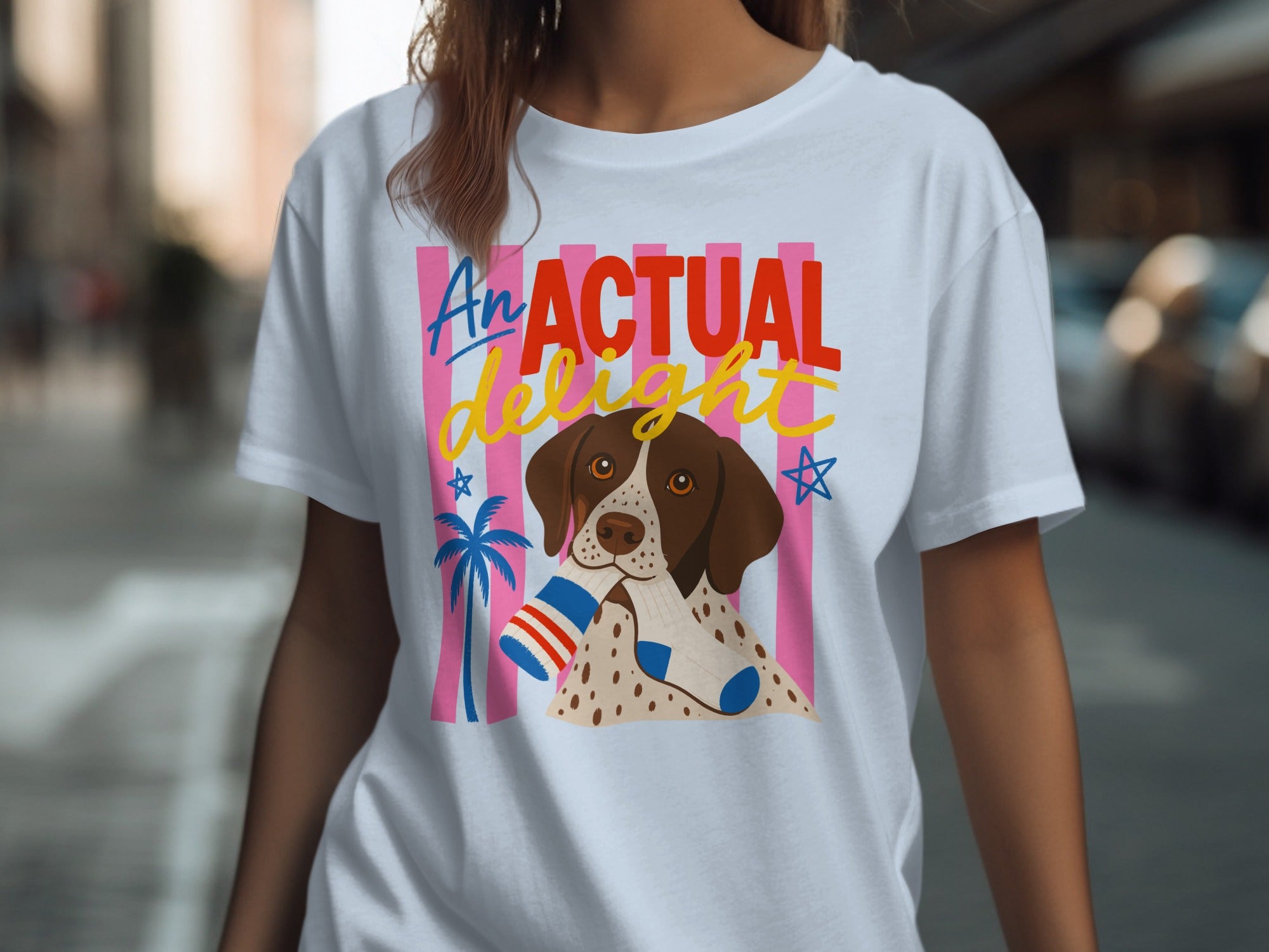 White t-shirt with a dog wearing socks and "An Actual Delight" text.