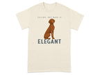 Brown dog sitting on a cream t-shirt with text "VELCRO, BUT MAKE IT ELEGANT".