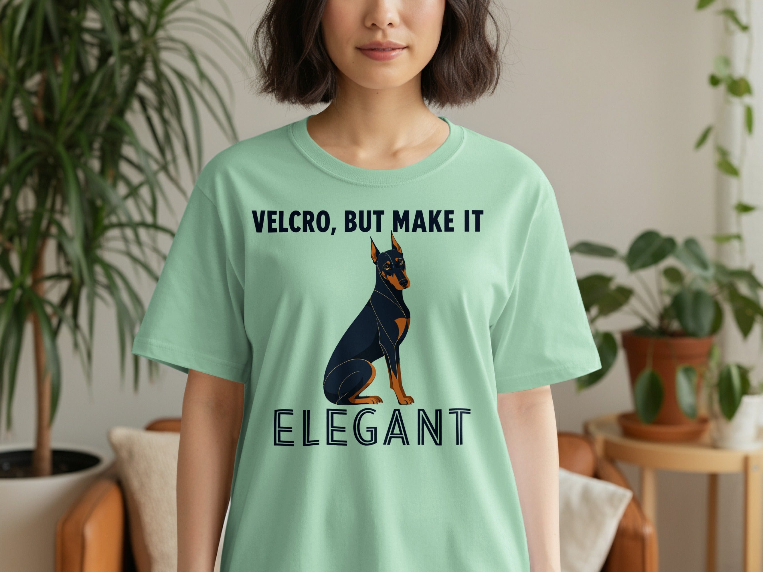 Light green t-shirt with Doberman dog graphic and text "VELCRO, BUT MAKE IT ELEGANT".
