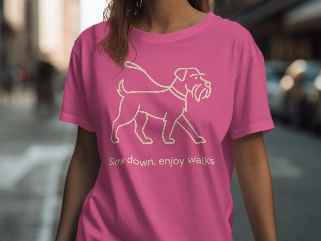 Pink t-shirt with line drawing of a dog on a leash and text "Slow down, enjoy walks."