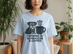 Light blue t-shirt with a schnauzer and coffee mug graphic, text reads "POWERED BY SCHNAUZER & COFFEE."