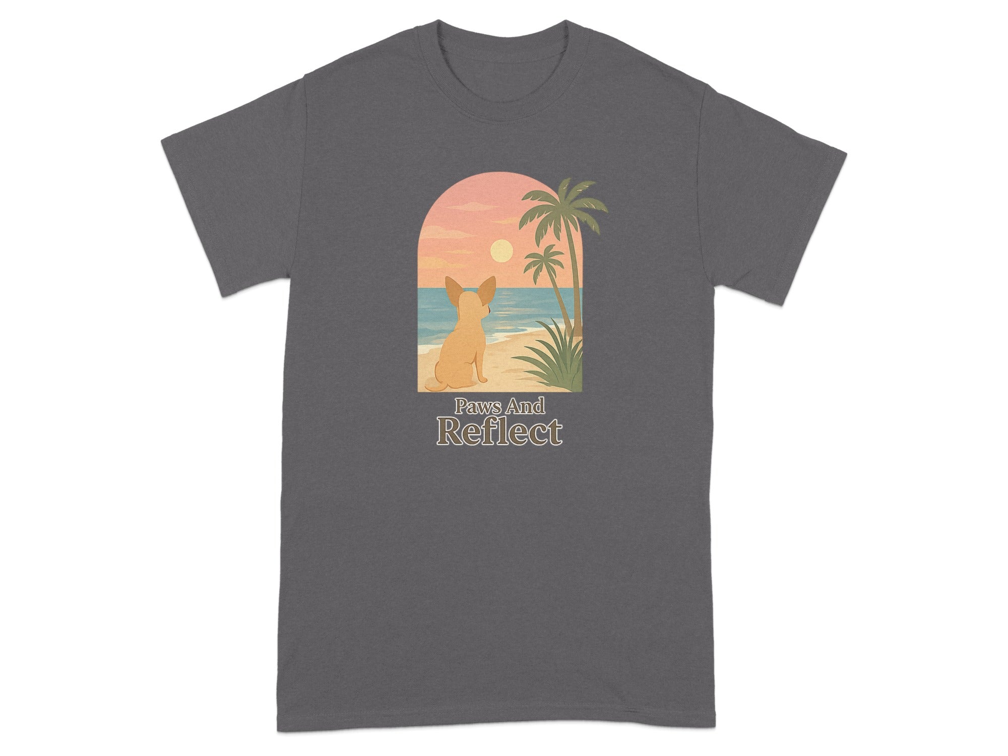 Grey t-shirt with a graphic of a dog on a beach at sunset with text "Paws And Reflect".