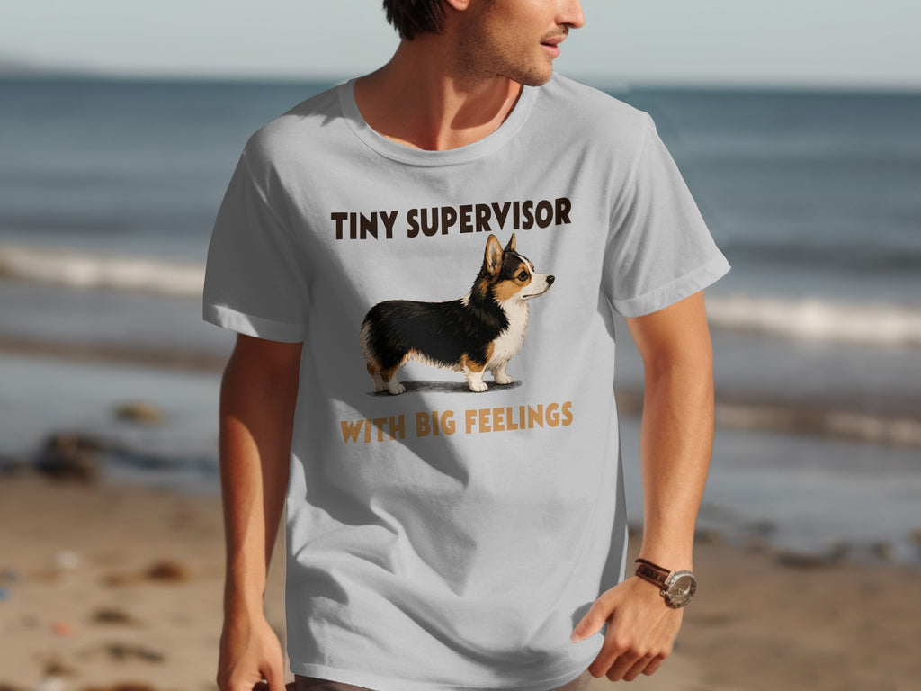 Man wearing a gray t-shirt with a corgi and text that reads "TINY SUPERVISOR WITH BIG FEELINGS".