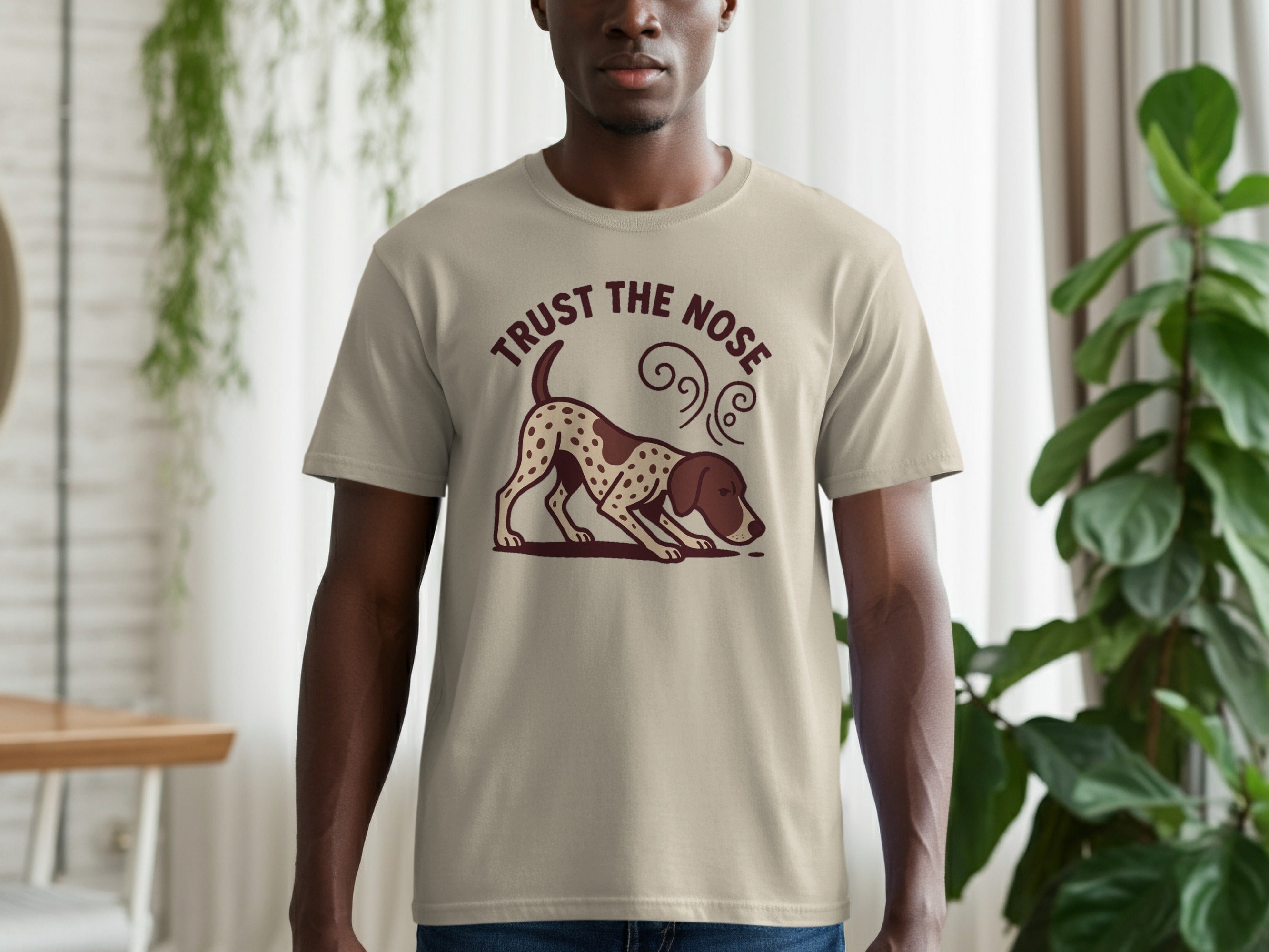Light tan t-shirt with graphic of a dog smelling the ground and text "TRUST THE NOSE".