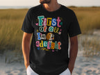 Black t-shirt with colorful "First of all, I'm a delight" text and cartoon dog.