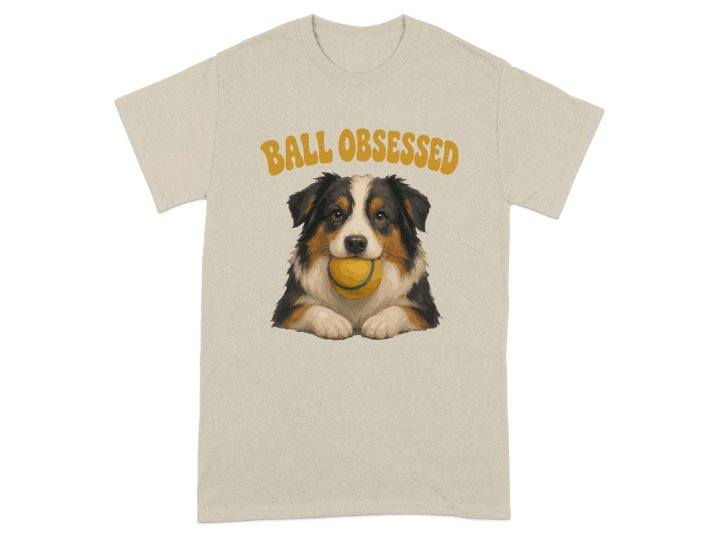 Beige t-shirt with illustration of an Australian Shepherd holding a yellow ball.