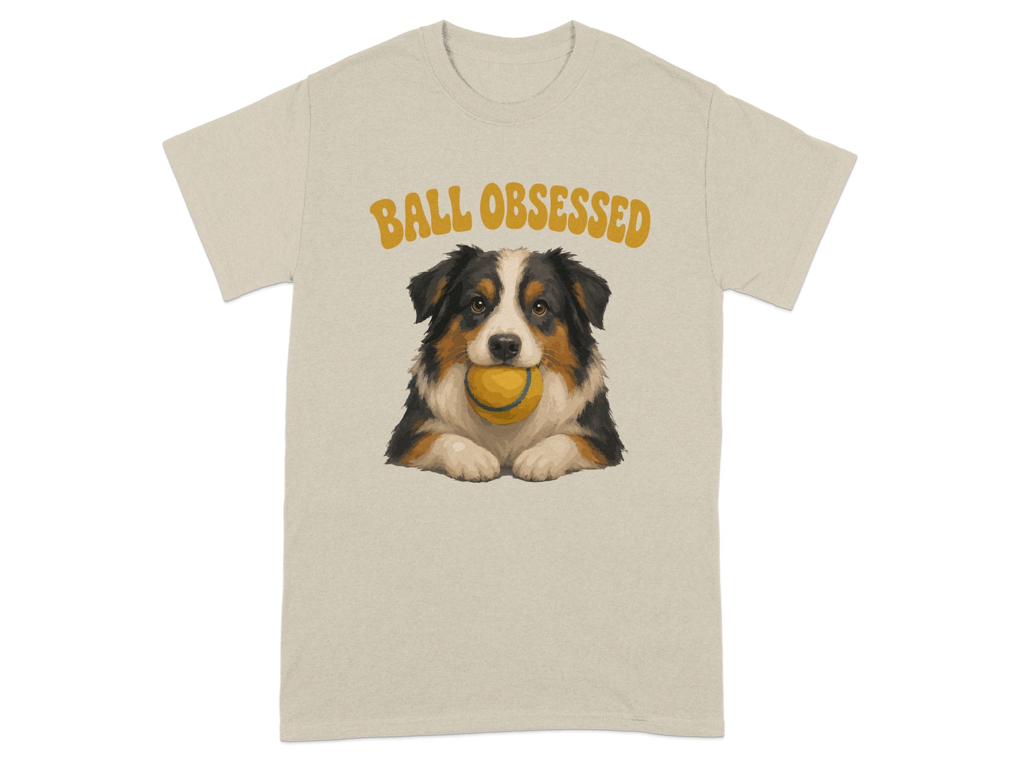 Beige t-shirt with illustration of an Australian Shepherd holding a yellow ball.