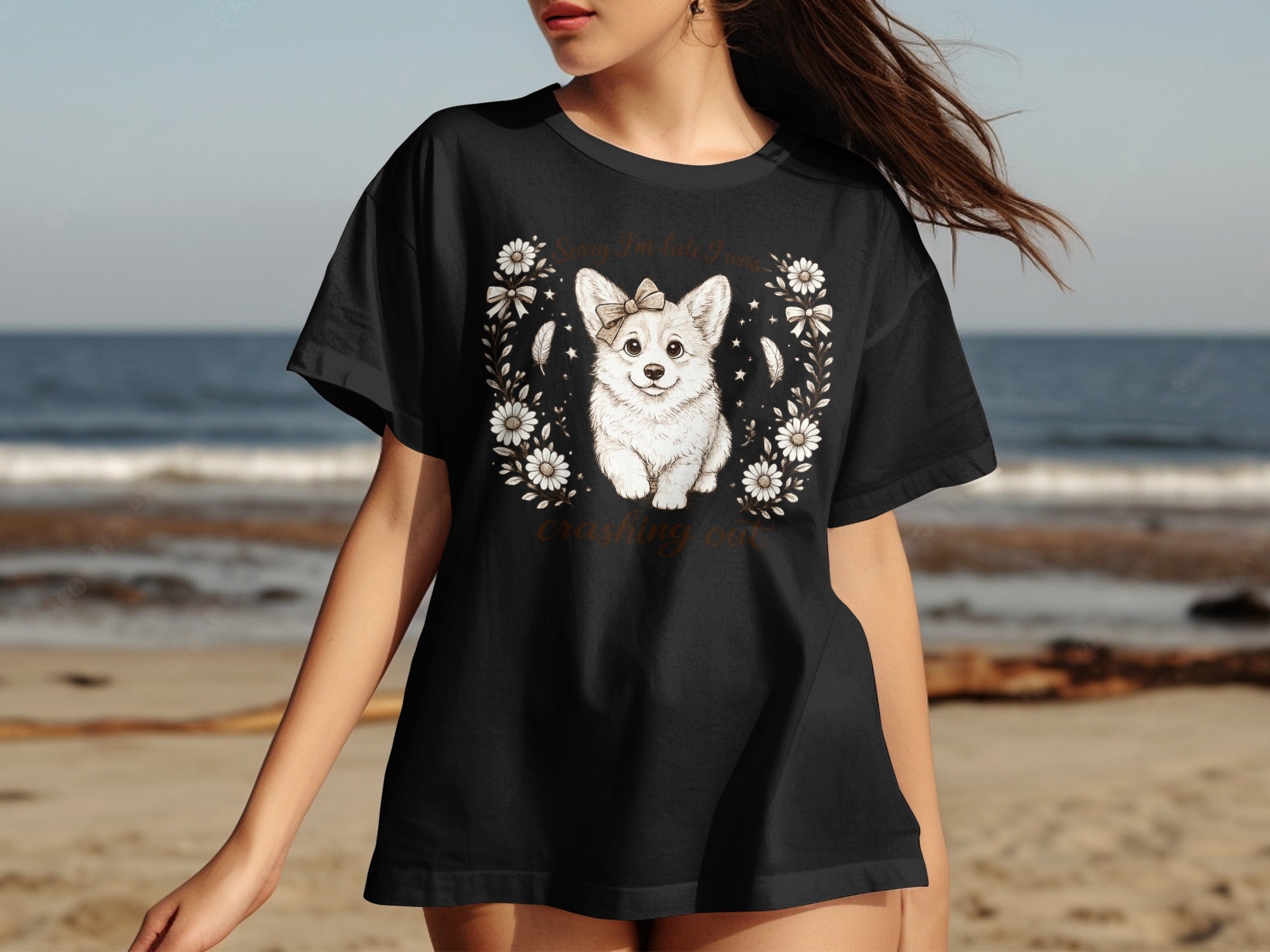 Black t-shirt with a white corgi wearing a bow on its head and text.