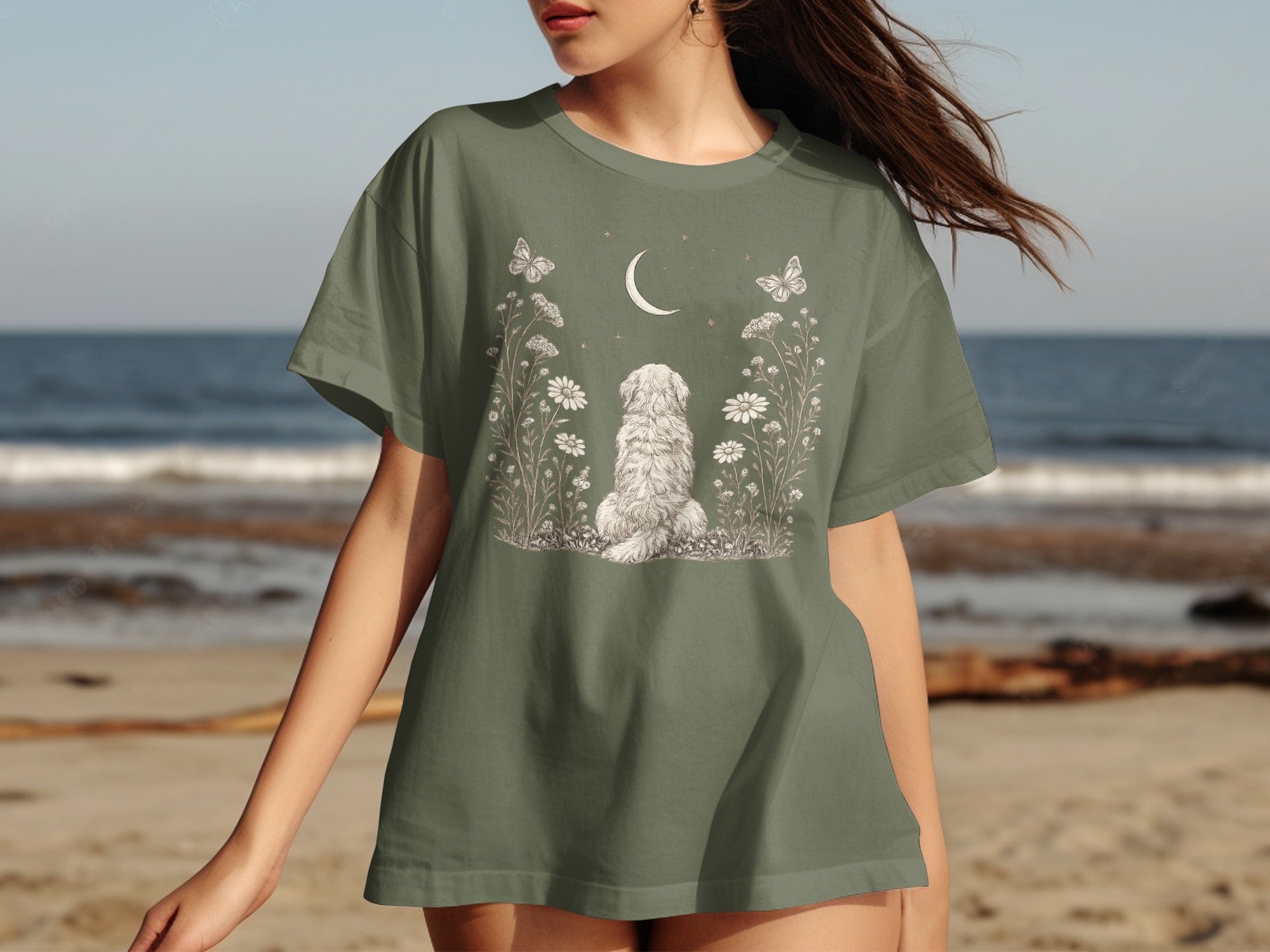 Green t-shirt with a shaggy dog, moon, butterflies, and wildflowers illustration.