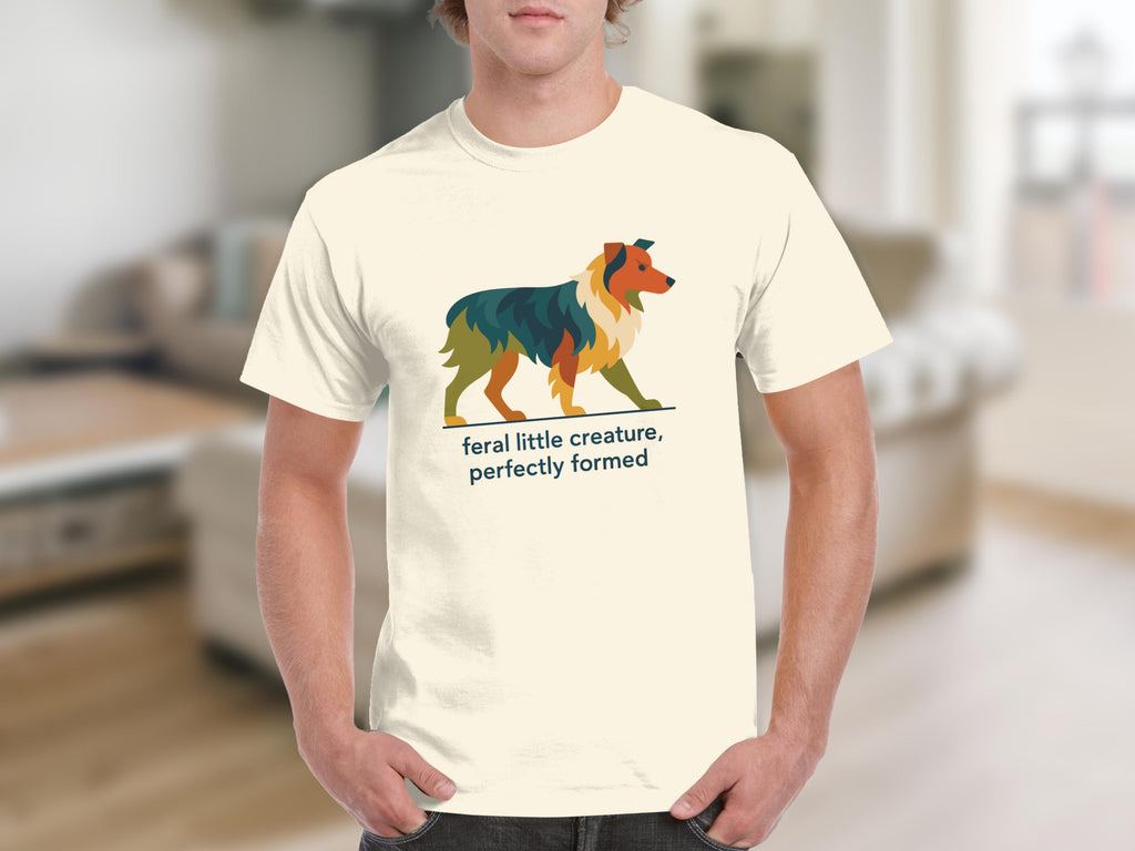 Cream t-shirt with geometric dog graphic and text "feral little creature, perfectly formed".