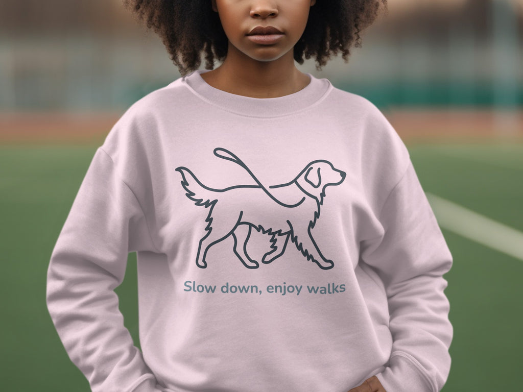 Light pink sweatshirt with a line drawing of a dog and the text "Slow down, enjoy walks".