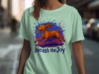 Mint t-shirt with running dog graphic and text "Unleash the Joy".