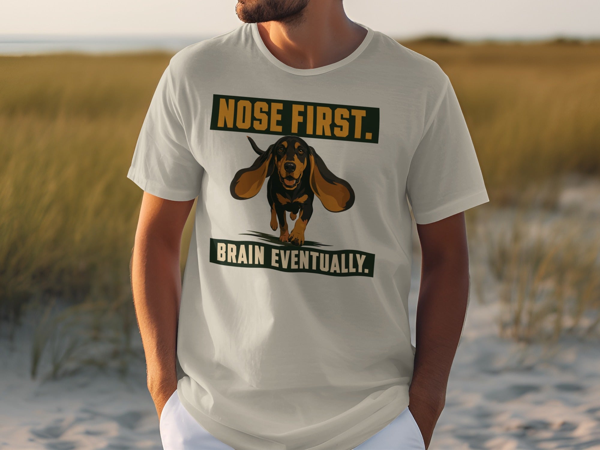 Cream t-shirt with "NOSE FIRST. BRAIN EVENTUALLY." and a dachshund graphic.