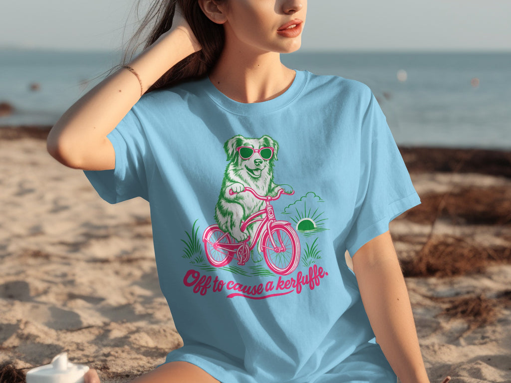 Light blue t-shirt with a cartoon dog riding a bicycle.