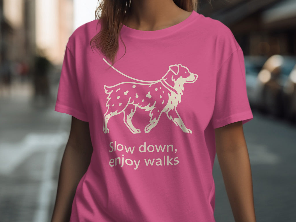 Pink t-shirt with a cream line drawing of a dog on a leash and text.