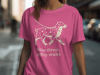 Pink t-shirt with a cream line drawing of a dog on a leash and text.