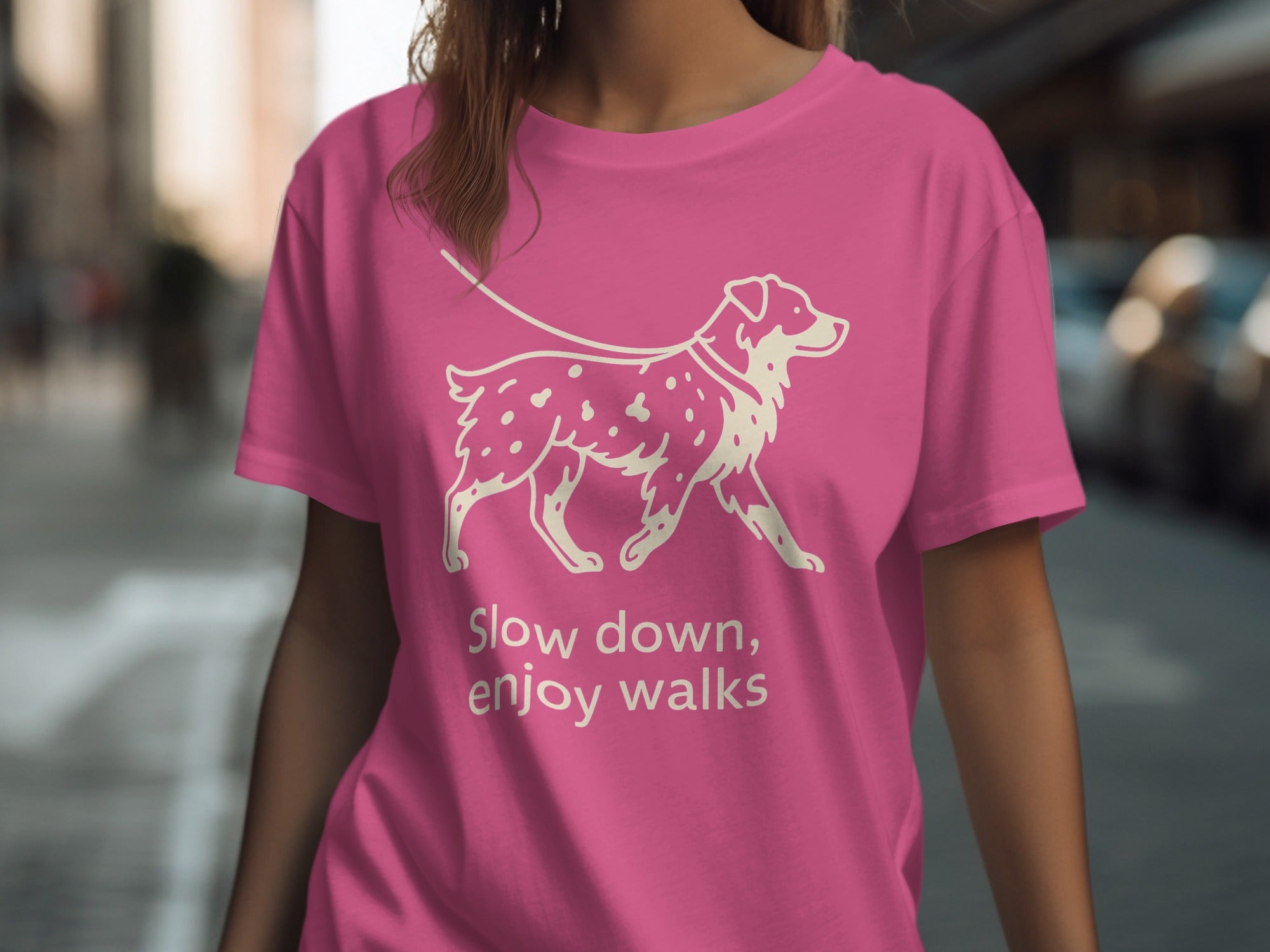 Pink t-shirt with a cream line drawing of a dog on a leash and text.