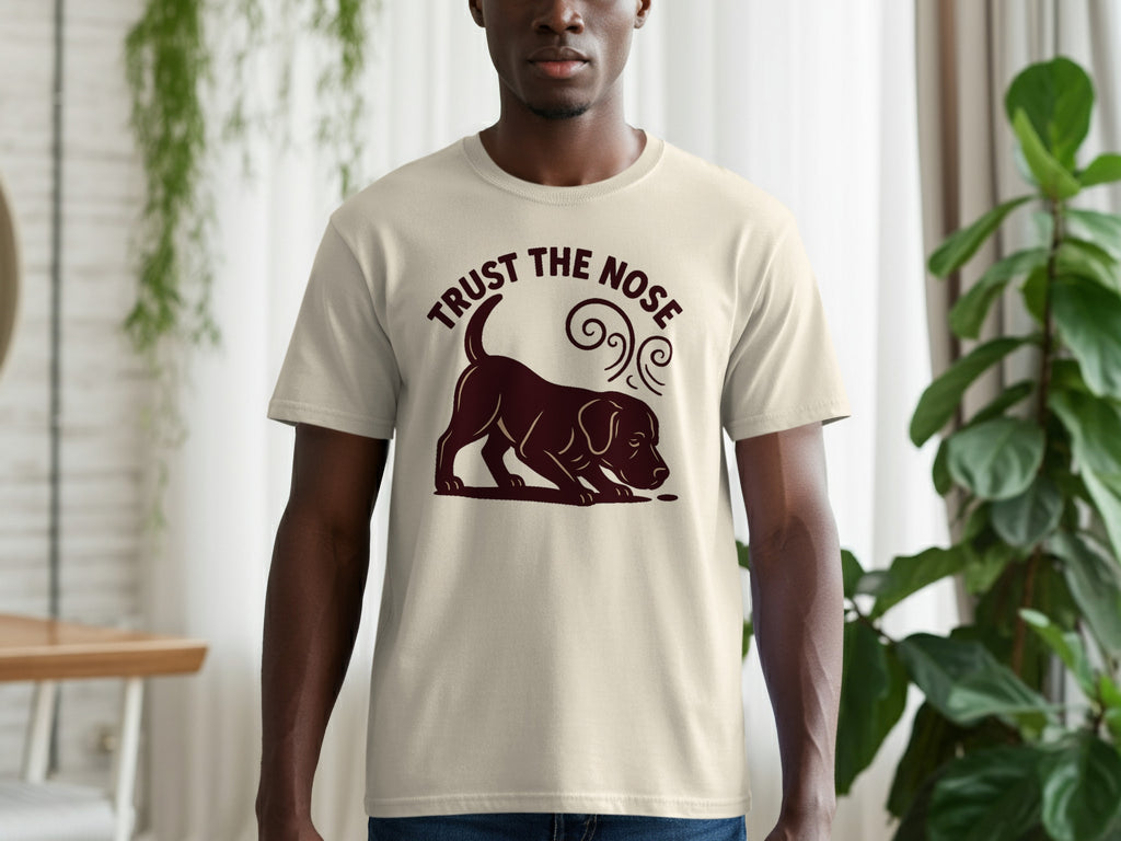 Light tan t-shirt with a dark brown graphic of a dog sniffing and the text "TRUST THE NOSE".